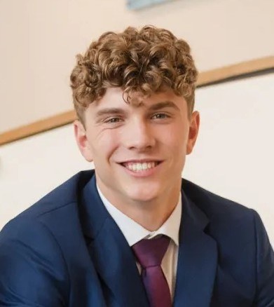 Pierson Jones in a navy suit and burgundy tie